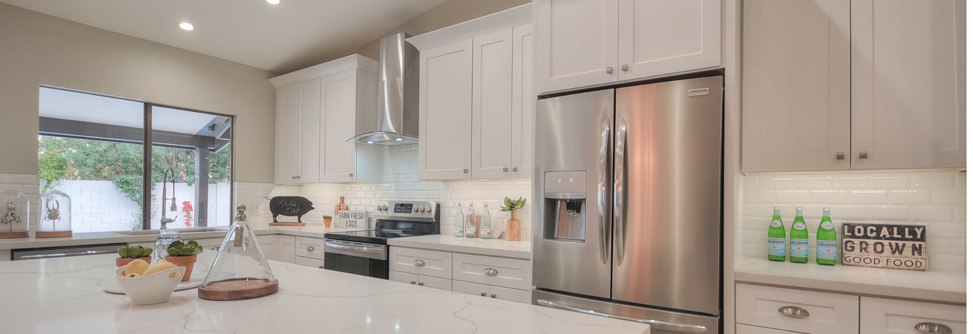 Modern kitchen with stainless steel appliances and white cabinetry.