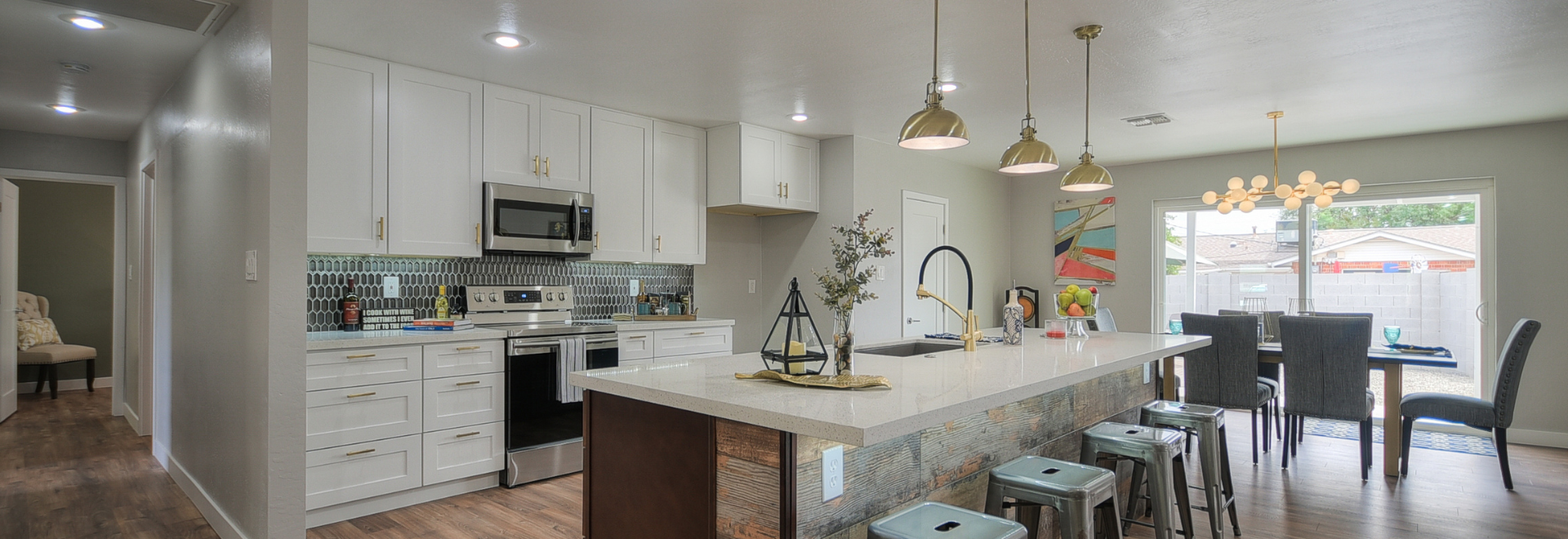 Modern kitchen with white cabinetry and large marble island.